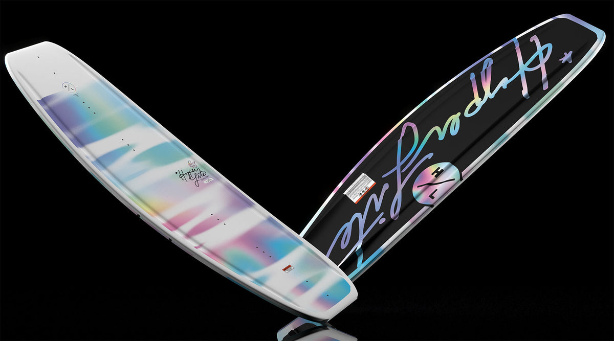 Angled view of Divine Jr. wakeboard with pastel top design and script logo on black base.