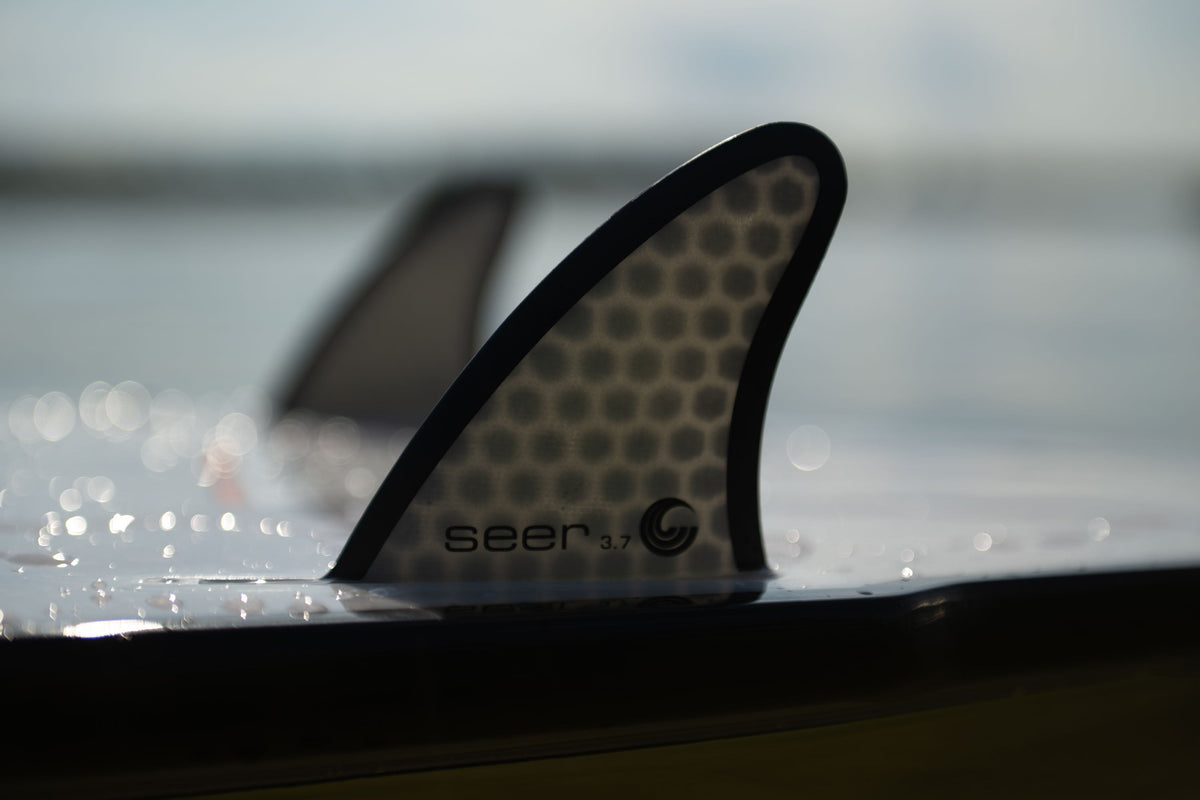 Close-up of the Seer wakesurf board‚Äôs fin, featuring a honeycomb pattern with ‚ÄúSeer 3.7‚Äù branding.