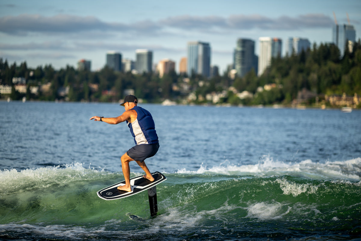 A city skyline frames a person gliding on a Starship w/Raptor 1100 Foil Kit.