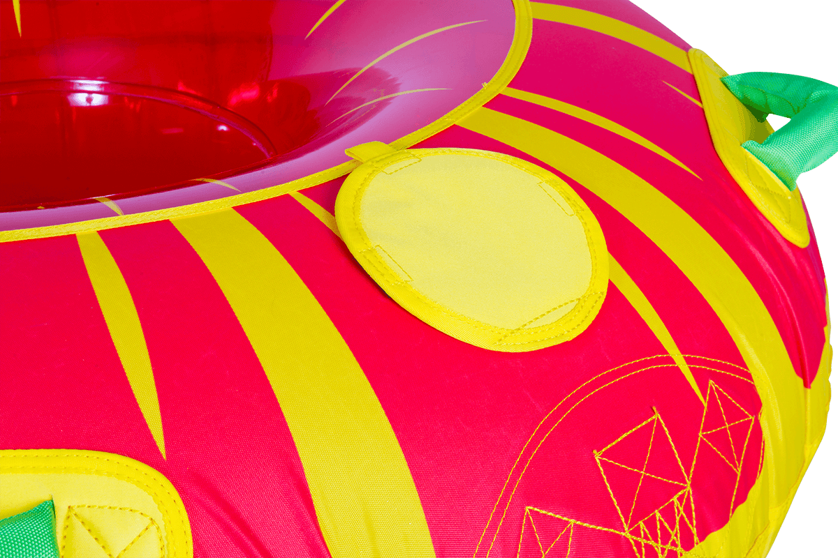 Close up of the Citrus towable tube, a red and yellow circular inflatable with green grab handles and a sunburst pattern.