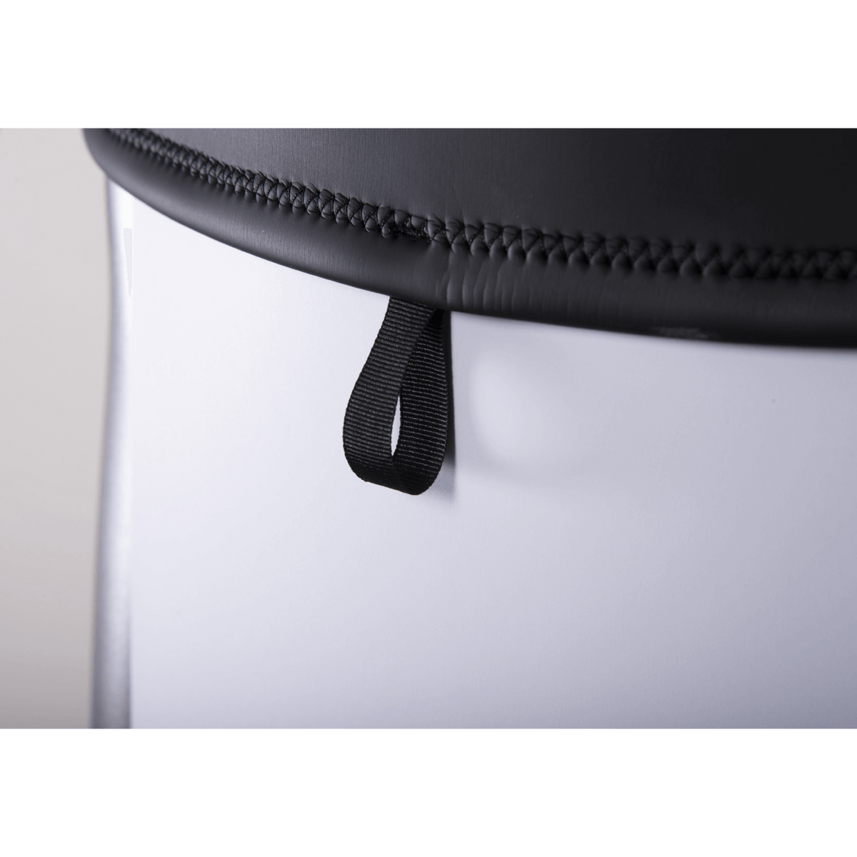 Close-up of the wetsuit hem, featuring a black stitched edge with a small pull loop for easy adjustments.